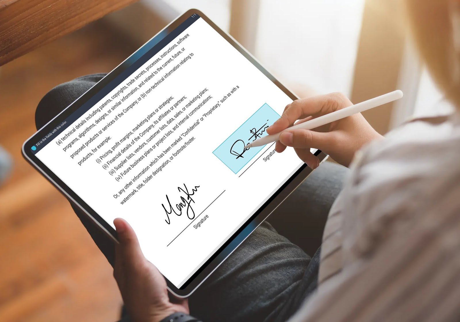 man writing signature on ipad